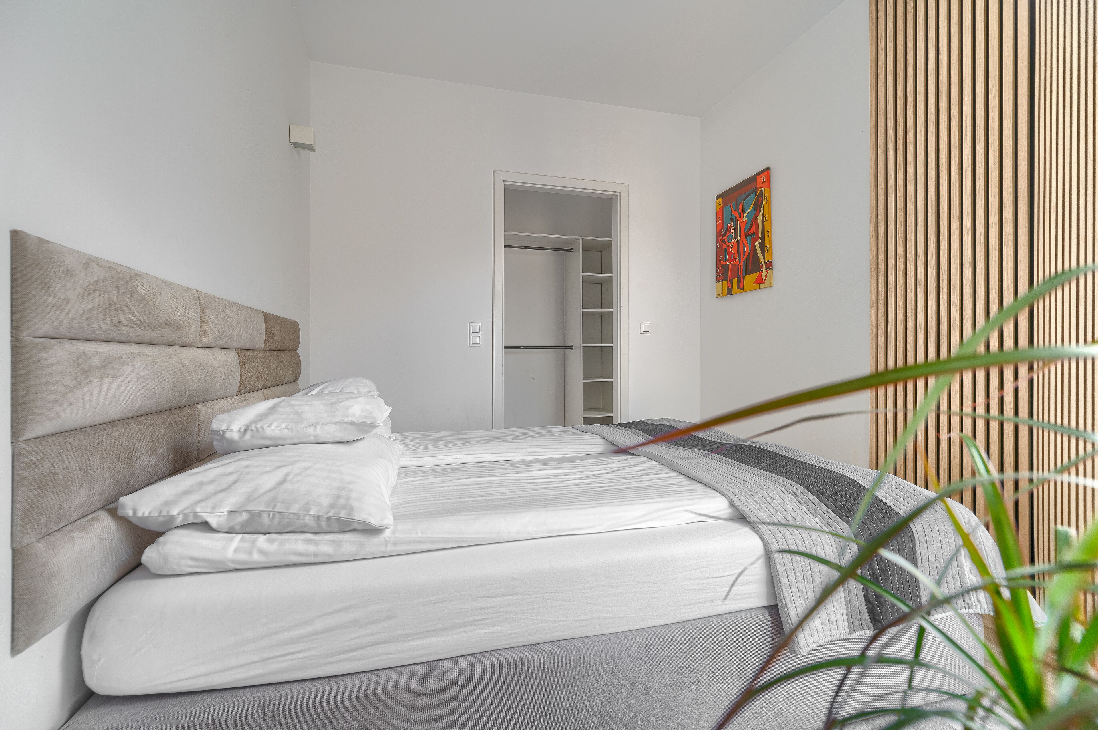 Um quarto com uma cama, um guarda-roupa e uma porta que dá para um closet.