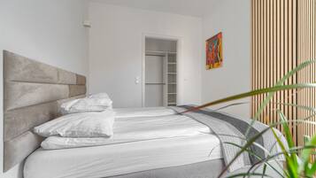 Um quarto com uma cama, um guarda-roupa e uma porta que dá para um closet.