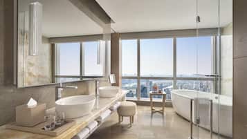 Un baño moderno con un ventanal grande, una bañera y un tocador con dos lavamanos.