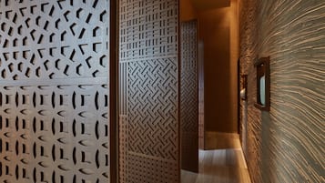 A hallway with patterned wooden panels and a textured wall.