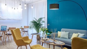 A modern living room with yellow chairs, a grey sofa, and a blue accent wall. - Residence Leopoldo (Florence)