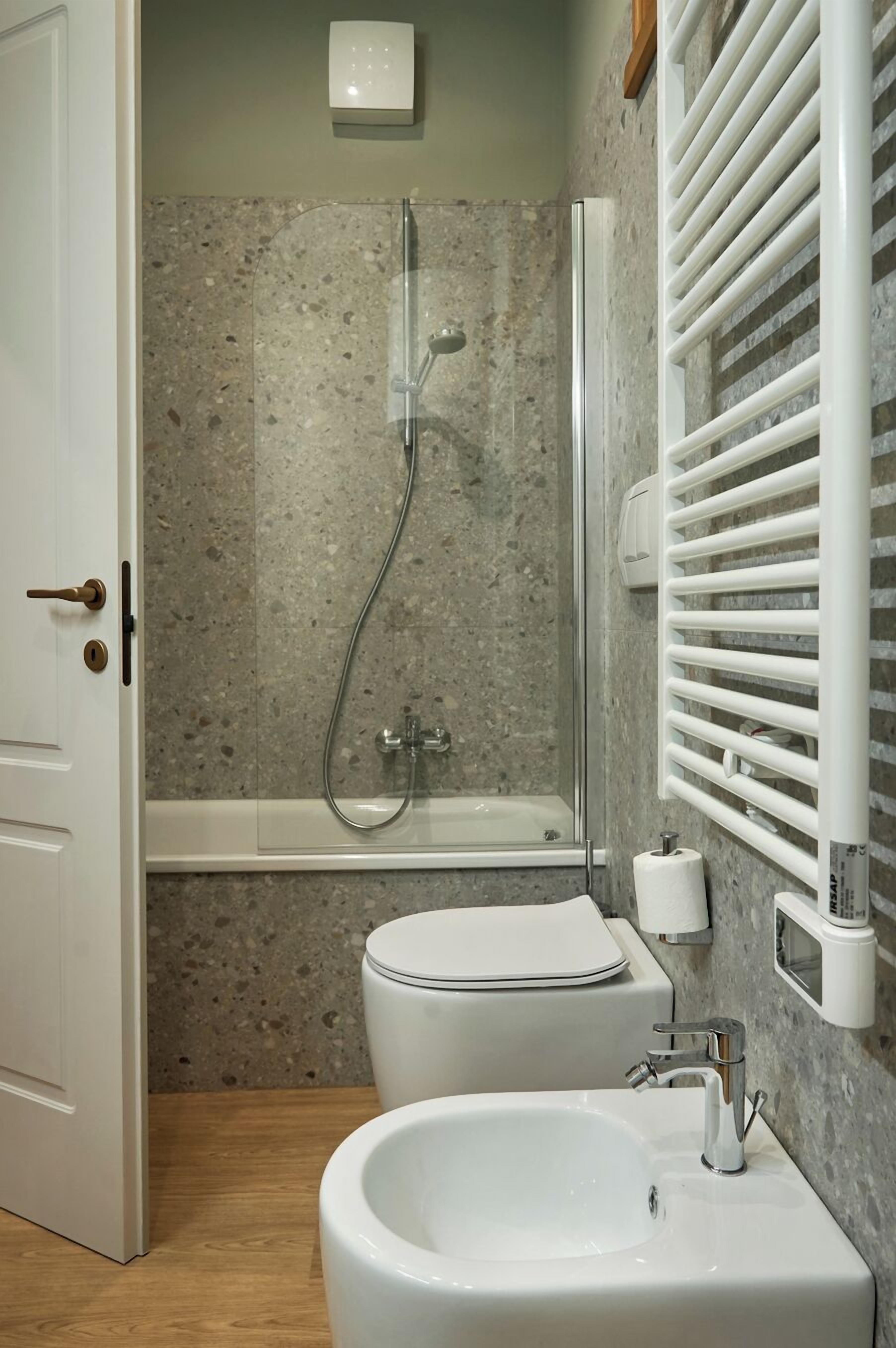 Ein modernes Badezimmer mit einer Duschkabine, einer Toilette und einem Waschbecken.