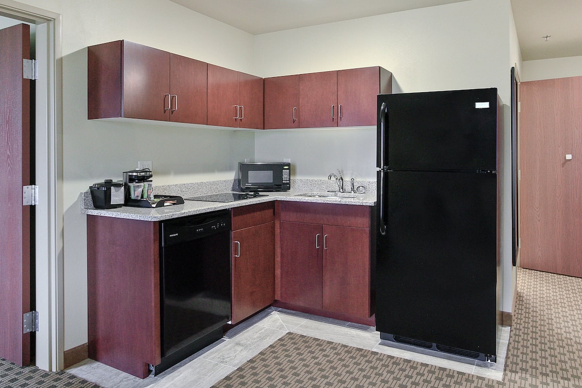A compact kitchen with a microwave, coffee maker, and refrigerator.