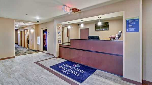 A hotel reception area with a marble floor, a reception desk, and a sign indicating the business center. - Cobblestone Hotel & Suites – Pulaski/Green Bay (Pulaski)