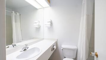 Ein modernes Badezimmer mit Waschbecken, Spiegel und Toilette in Weiß.