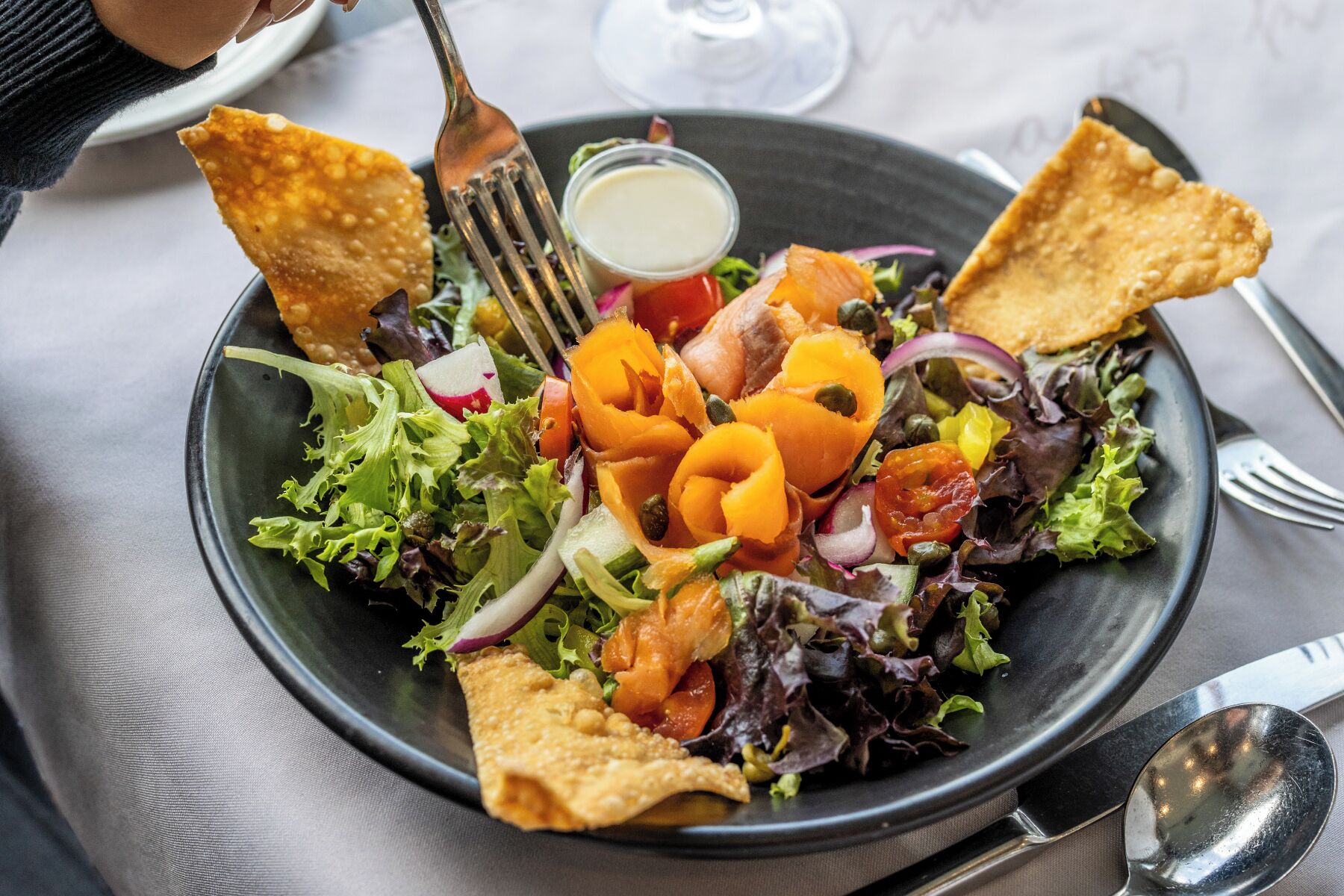 Un plato de comida con ensalada, verduras y papas fritas.