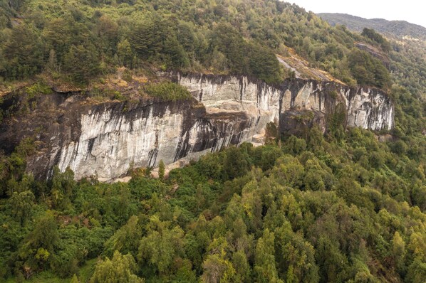 Une falaise naturelle, entourée d’une forêt dense.