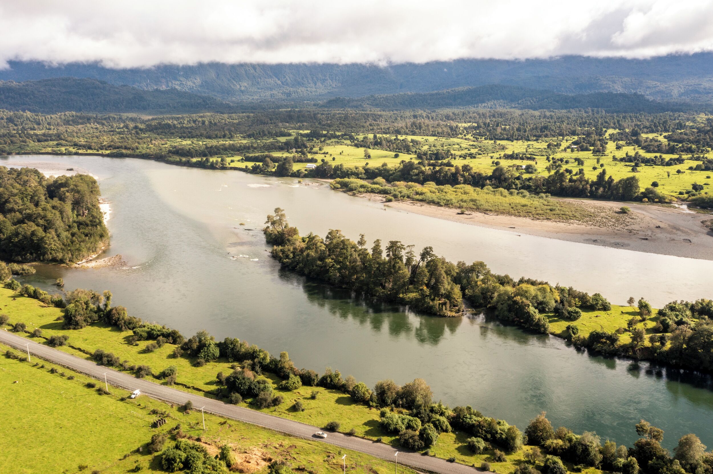 A river winding through a green landscape with a road running alongside.