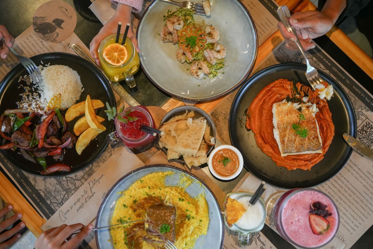 Una mesa con varios platos, incluyendo arroz, camarones y un guiso de salsa roja.