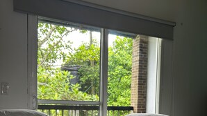 Une chambre d’hôtel avec deux lits, une grande fenêtre et un balcon.