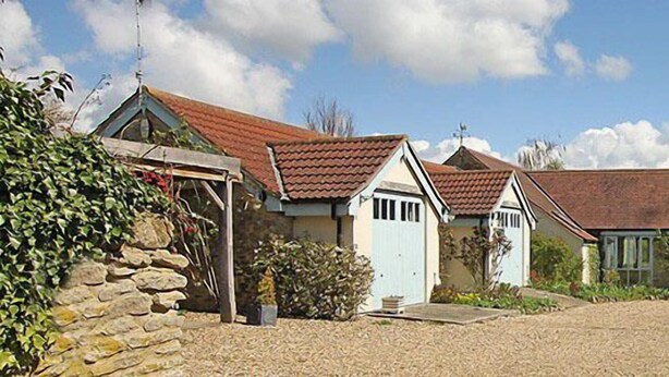 Un charmant village avec ses maisons traditionnelles en pierre, une allée de gravier et une pancarte indiquant « Munden House ».