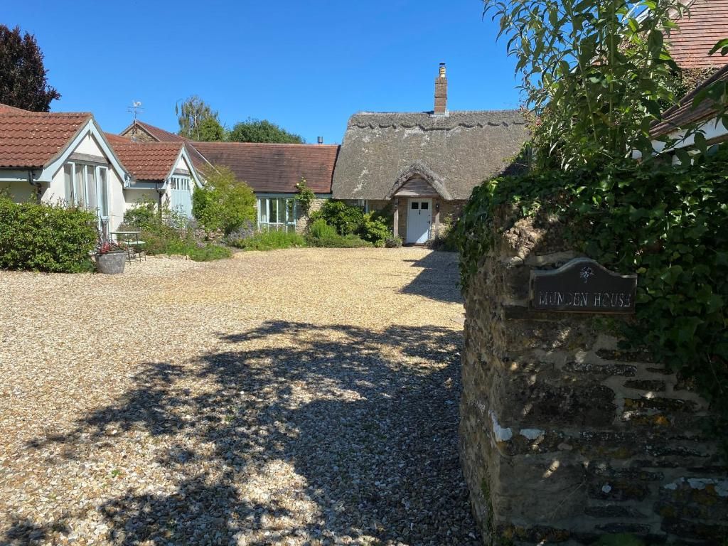 A traditional house with a gravel driveway leading to a wooden door labeled 'HUNTEN HOUSE.'
