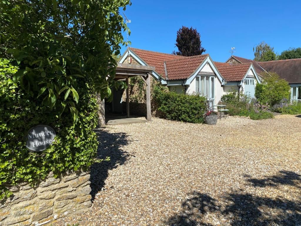 A house with a gravel driveway and a sign that reads 'Murder House.'