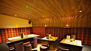 A restaurant with booths and tables, wooden ceiling, and red and black striped walls. - St Ola Hotel (Kirkwall)