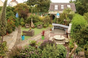 A garden with a patio area, seating, and a small structure. - Western House B and B (Swansea)