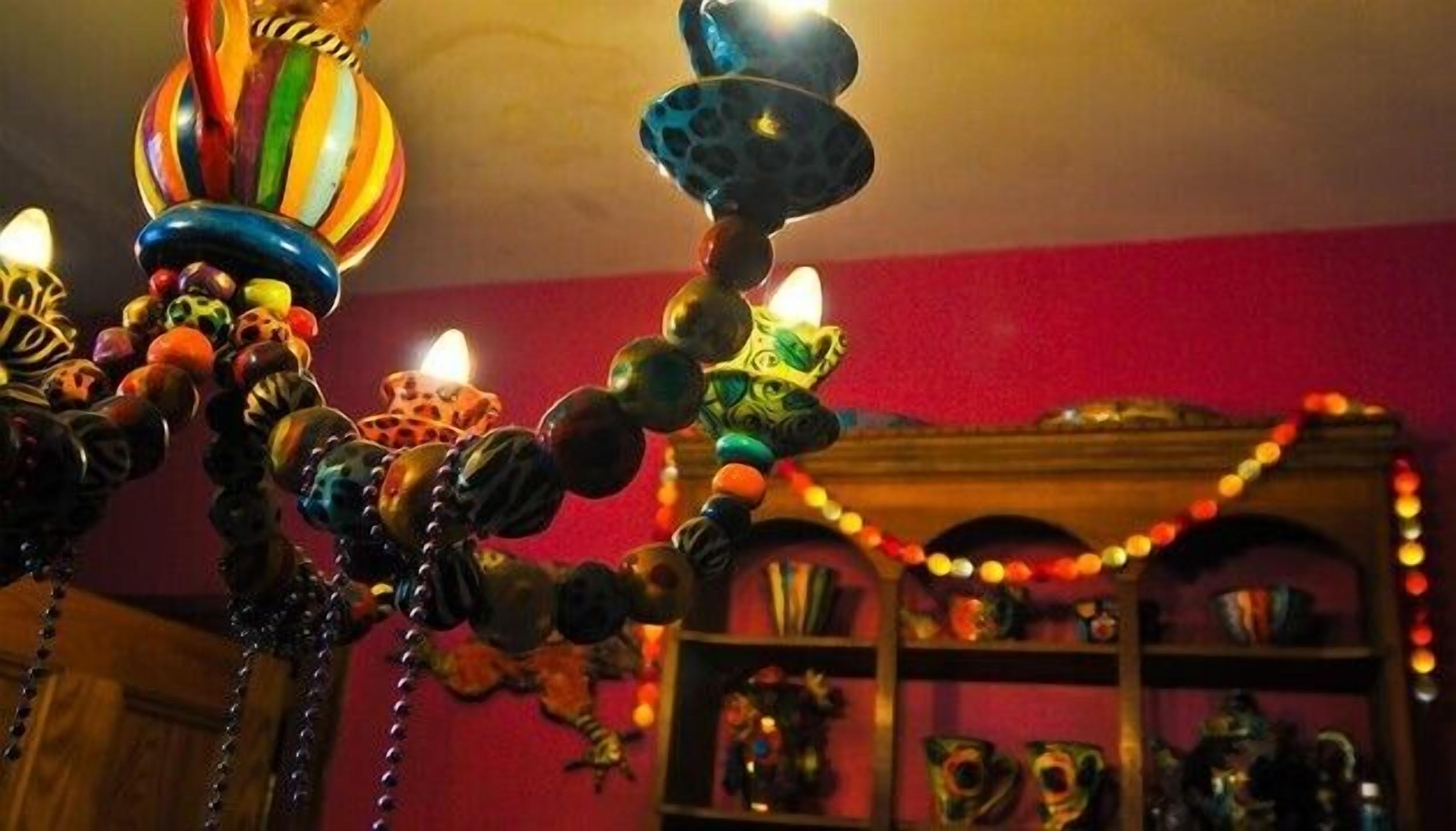 Una habitación con una pared roja y una estantería con varios objetos decorativos.