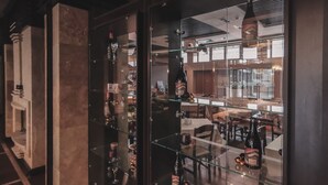 A modern interior with a glass display case containing various bottles and glasses. - Trinity Residence Bansko (Bansko)