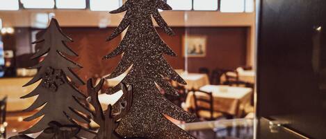 A wooden Christmas tree decoration in a dining area with tables and chairs.