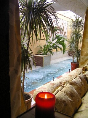 A room with a view of a water feature, potted plants, and a candle on a table. - Friends Hotel Bansko (Bansko)