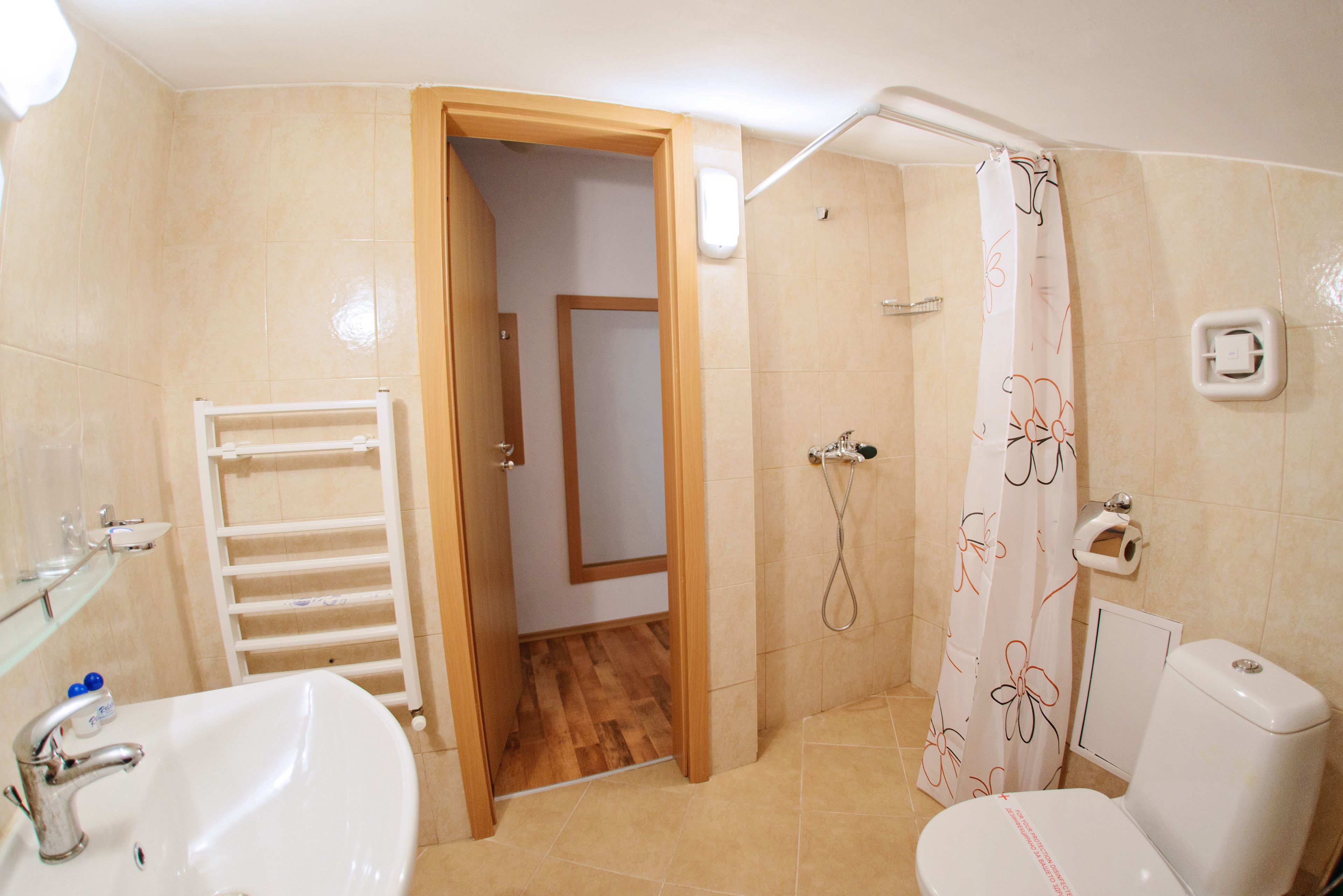 A bathroom with a sink, toilet, shower, and a towel rack.