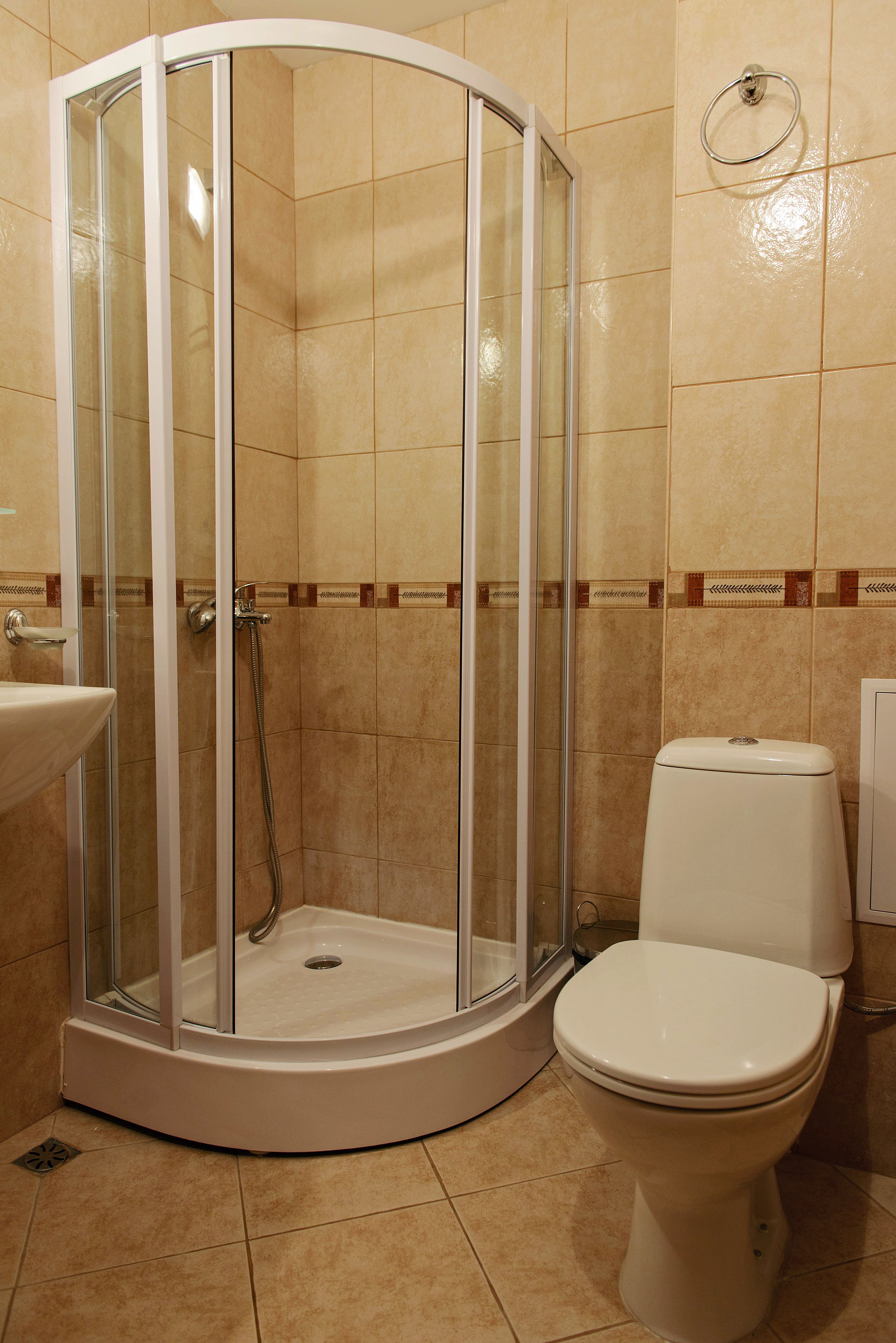 Un baño con ducha de vidrio, inodoro y lavamanos.