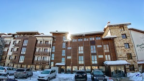 A multi-story hotel with a stone facade and wooden balconies, featuring a sign for Mountain View Resort. - Mountain View Resort (Bansko)