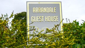 Schild für das Arrandale Guest House mit einer einfachen Umrisszeichnung eines Gebäudes.
