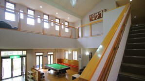 A multi-level recreational area with a pool table, seating, and a staircase. - Kounso (Yamanakako)