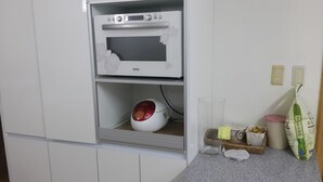 A kitchen with a microwave, a rice cooker, and a glass of water on the counter. - Spacious Apartment in Central Seoul (Seoul)