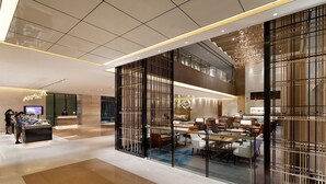 A modern hotel lobby with a reception desk, seating area, and a glass partition with decorative elements. - Courtyard by Marriott Zhengzhou East (Zhengzhou)