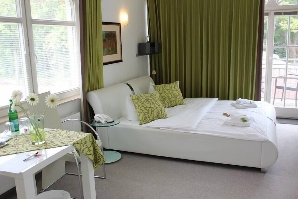 Une chambre d’hôtel avec un lit, un bureau et une fenêtre.