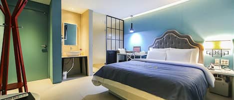 Een hotelkamer met een bed, een bureau, een stoel, een bureaulamp en een spiegel.