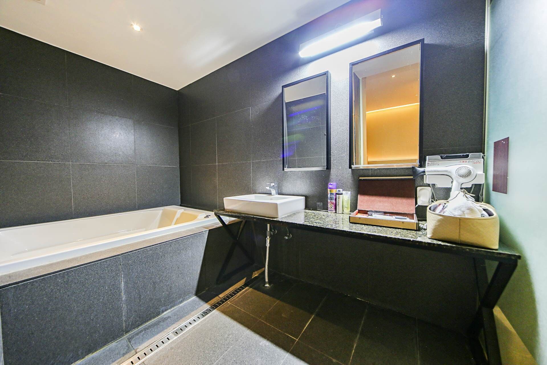 A modern bathroom with a bathtub, a sink, and a mirror.