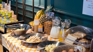 A buffet table with various food items including fruits, condiments, and beverages. - Hotel Myeongjak (Chuncheon)