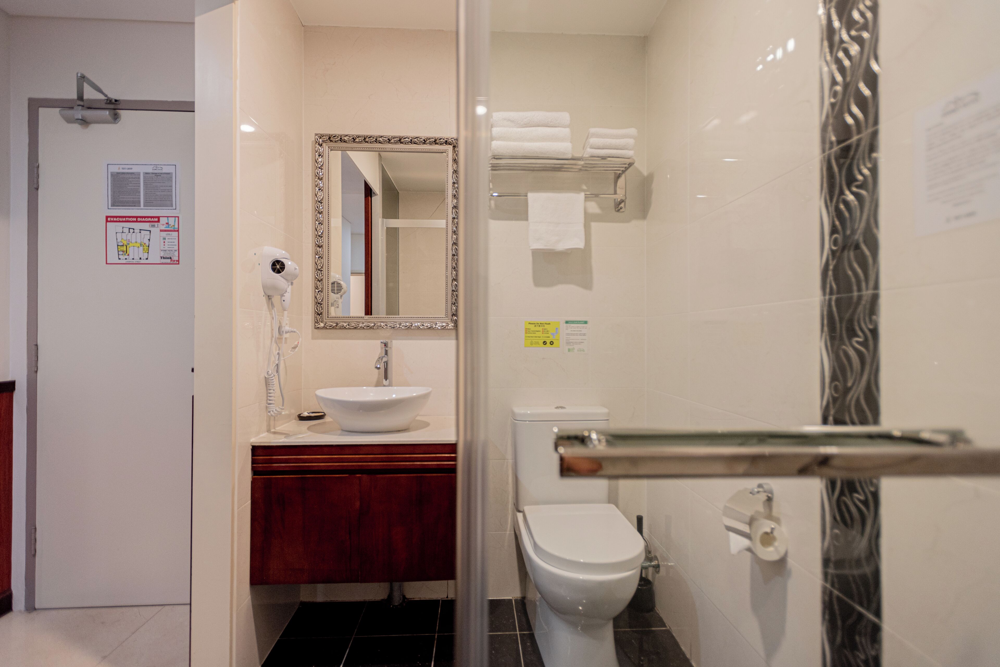 A bathroom with a sink, mirror, toilet, and towel rack.
