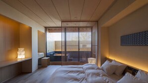 A modern hotel room with a large bed, bedside tables, a desk, and a sliding shoji screen door. - Chikurakan (Minamiboso)