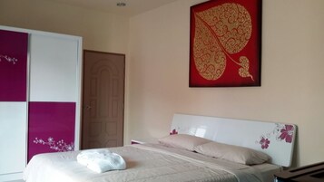 Un dormitorio con cama, armario y un gran elemento decorativo en la pared.