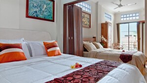 A hotel room with two beds, a balcony, and artwork on the walls. - Kuta EcoStay (Kuta)