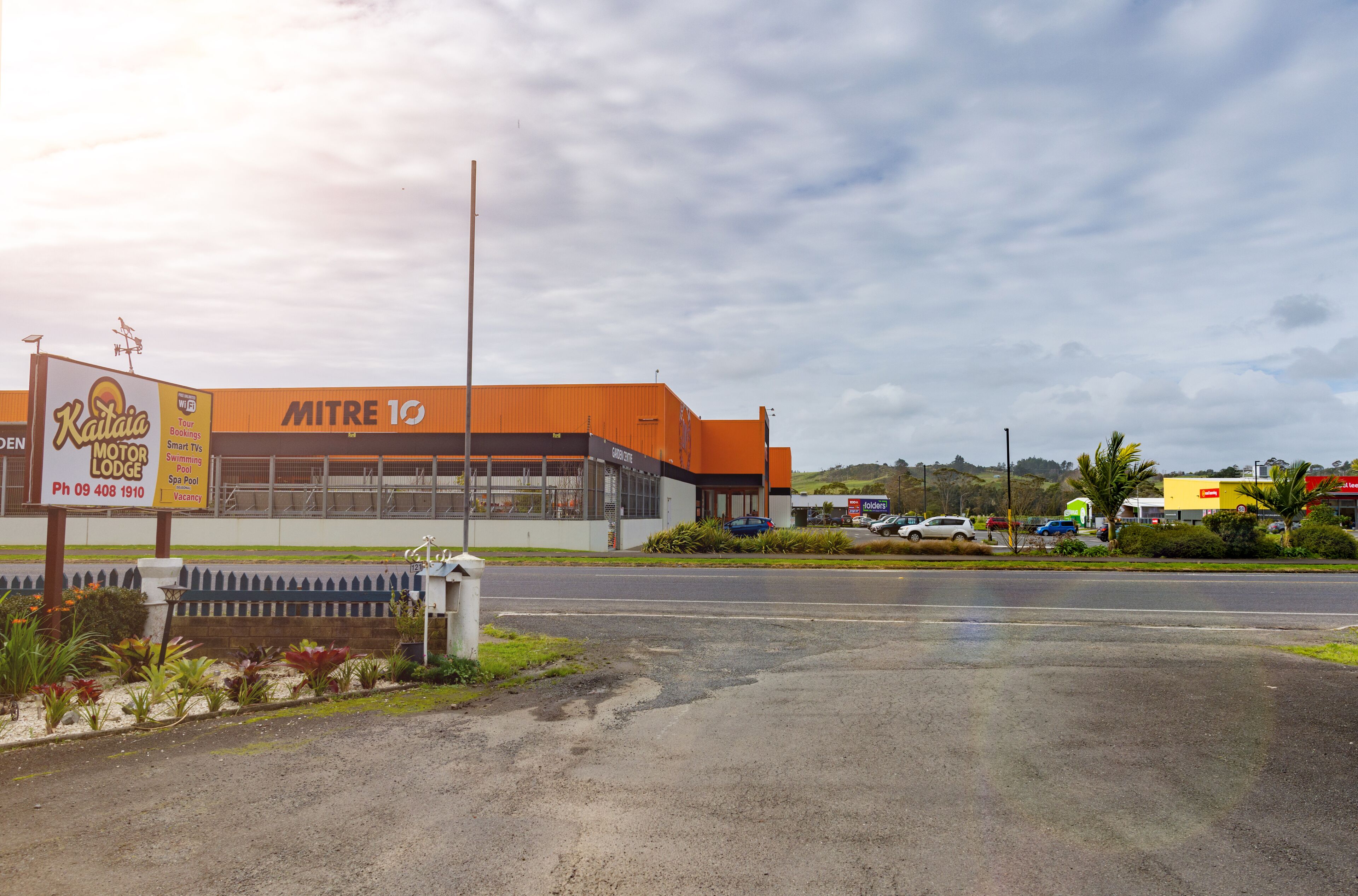 A building with a sign for 'Kaitai Lodge' and 'MITRE 10' on the facade.