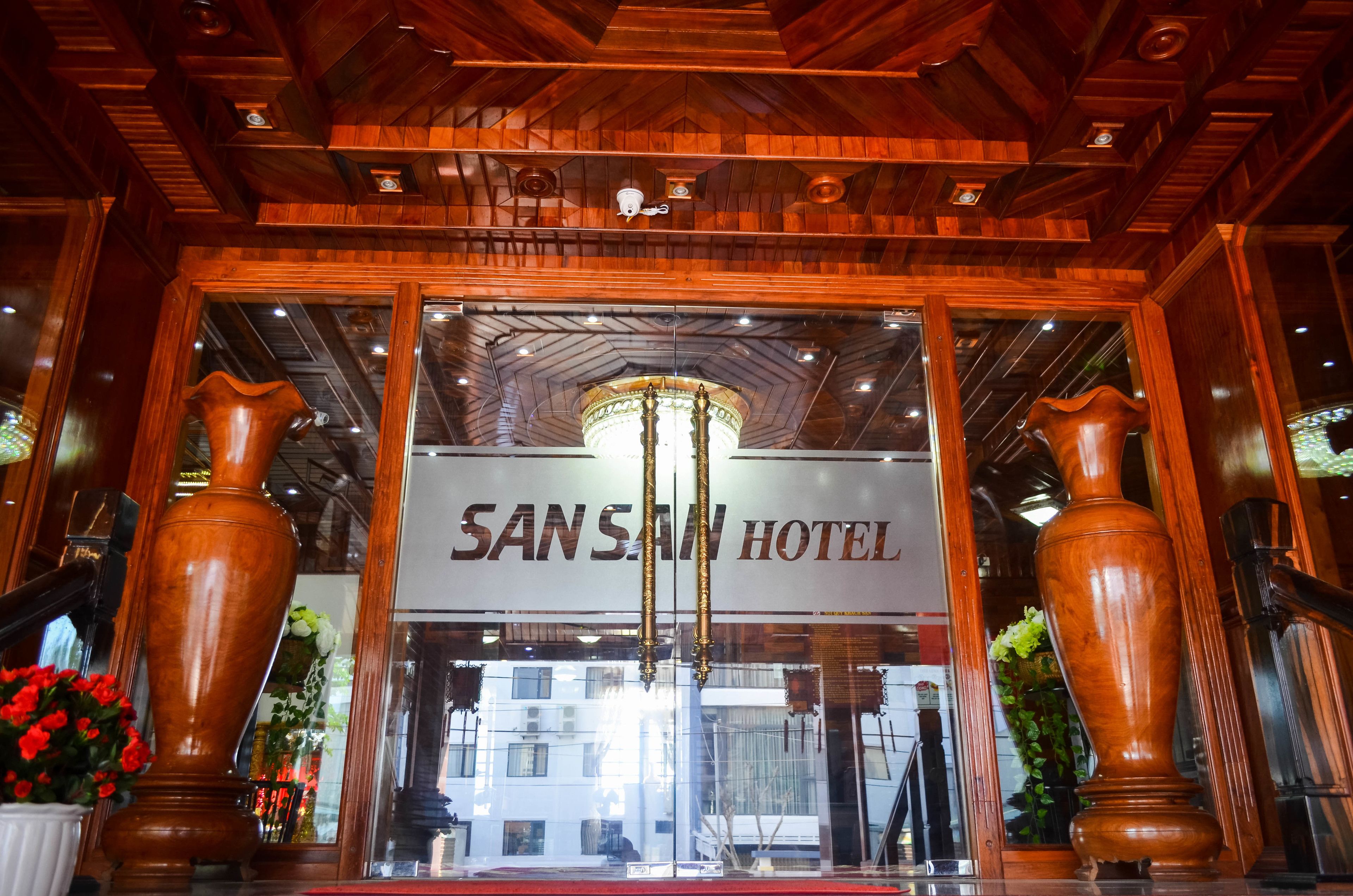 La entrada del Hotel Sansan, con fachada de madera y un letrero sobre la puerta.