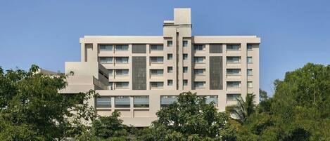 A modern multi-story building with a symmetrical facade, large windows, and a central vertical element.