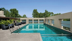 A pool area with lounge chairs and a clear view of the sky. - The Fern Residency Pune, Vadgaon-Talegaon, Series by Marriott (Mawal)