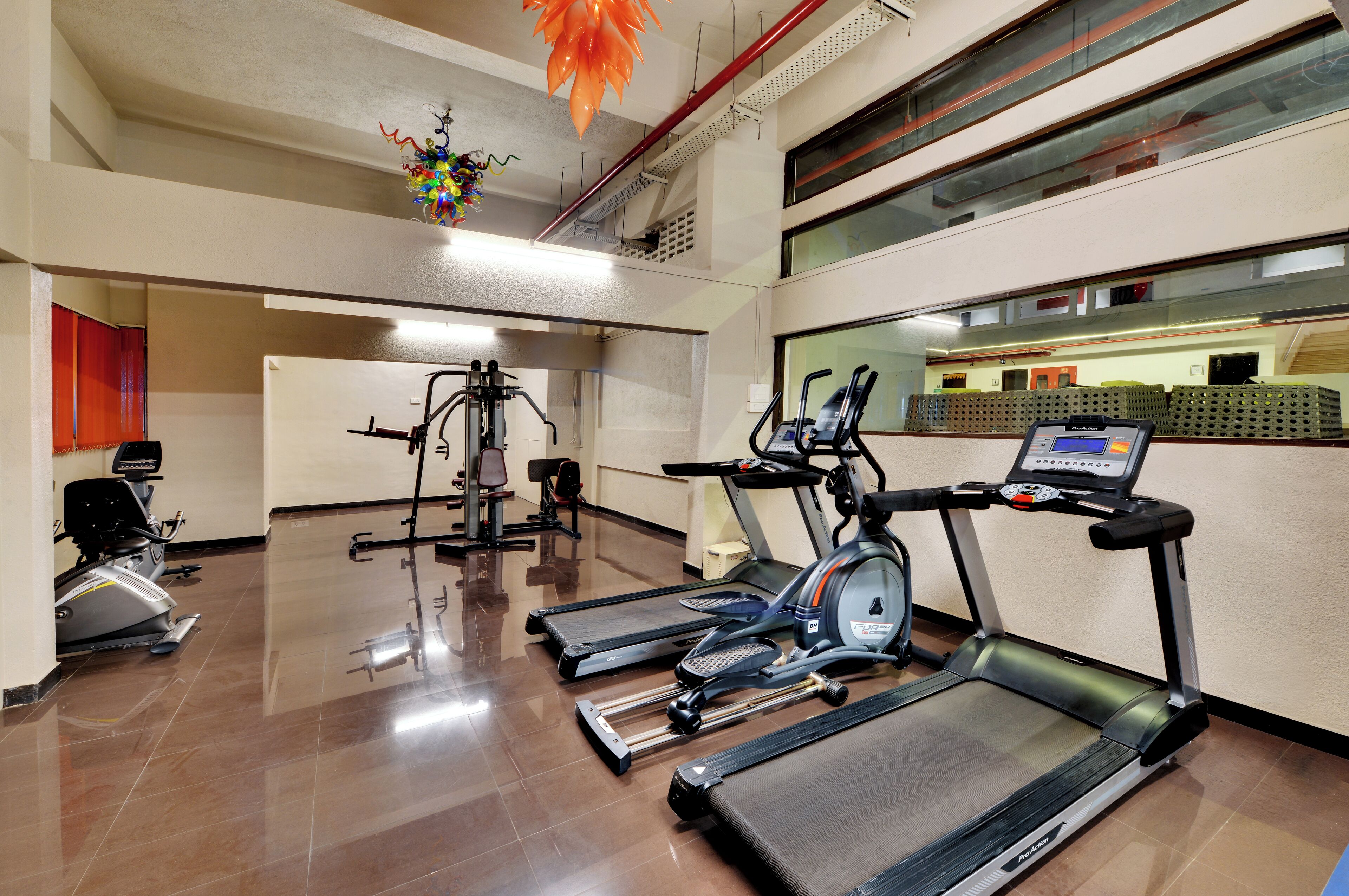 Un gimnasio con cintas de correr, elípticas y bicicletas estáticas.