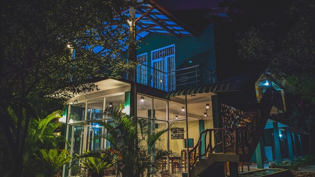 A two-story building with a glass facade, surrounded by lush greenery. - Sigiri Choona Lodge (Sigiriya)