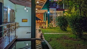 A modern building with a glass facade, outdoor seating area, and a small pool. - Sigiri Choona Lodge (Sigiriya)