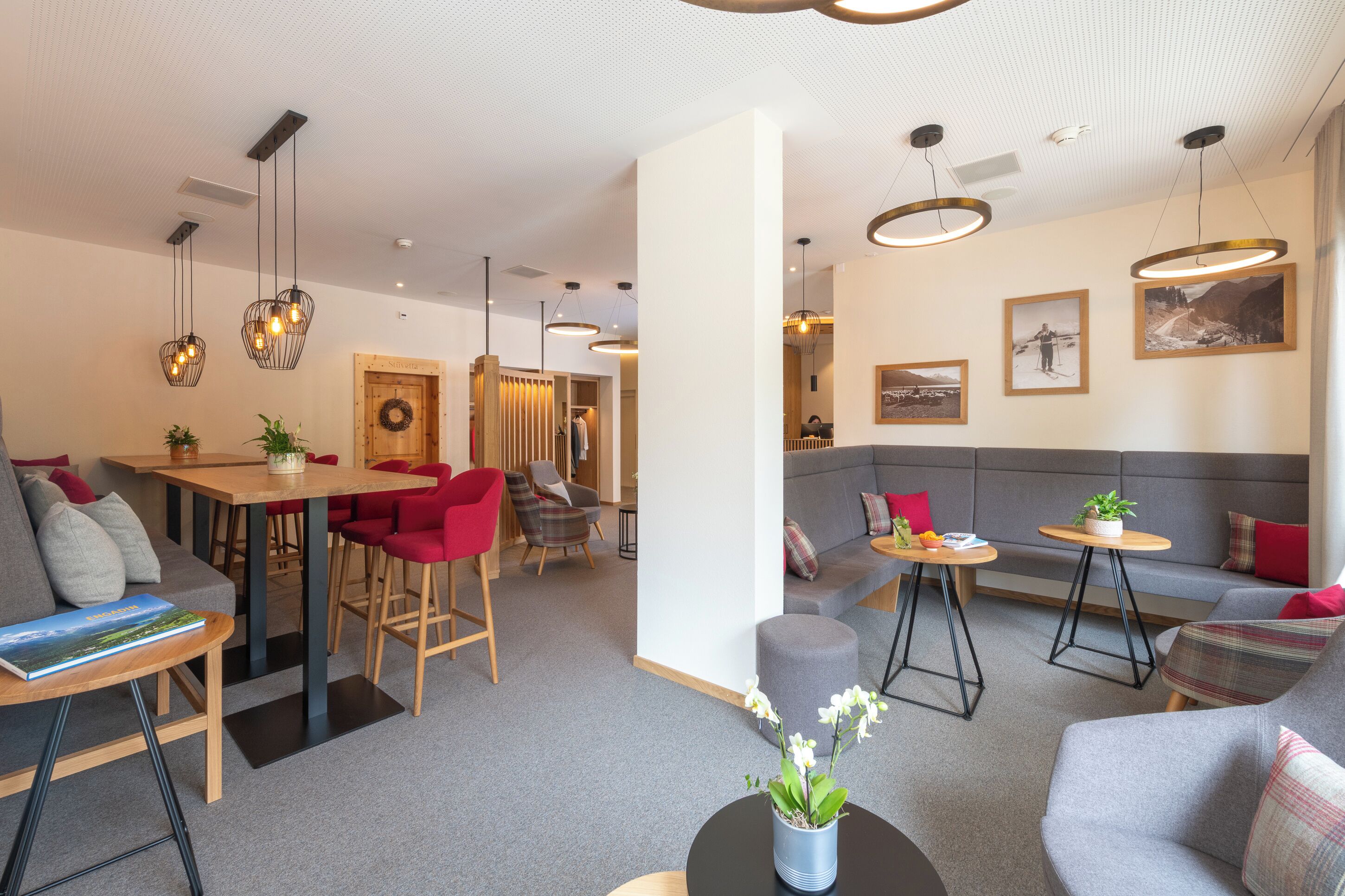 Un hall d’hôtel moderne comprenant un espace repas, des coins salon et des œuvres d’art accrochées aux murs.