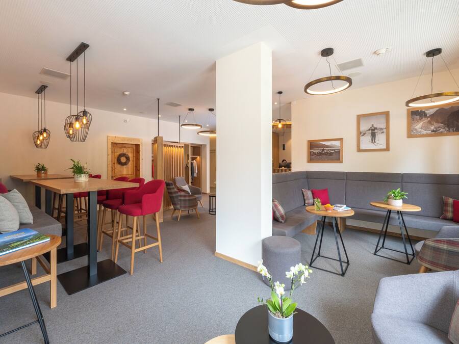 A modern hotel lobby with a dining area, seating arrangements, and artwork on the walls.