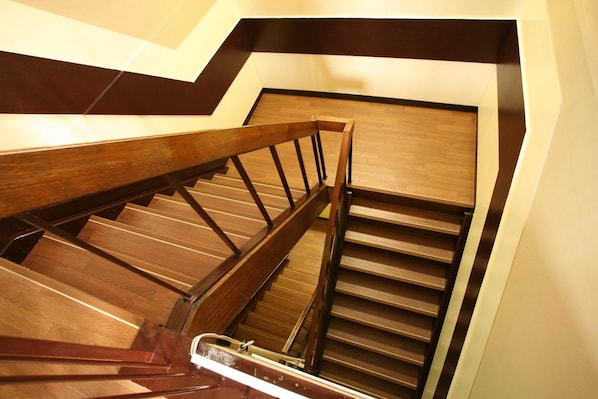 A wooden staircase with a metal handrail and wooden steps. - Guesthouse Danran (Beppu)