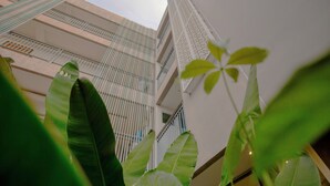 Un immeuble à plusieurs étages doté de balcons et d’un atrium central.