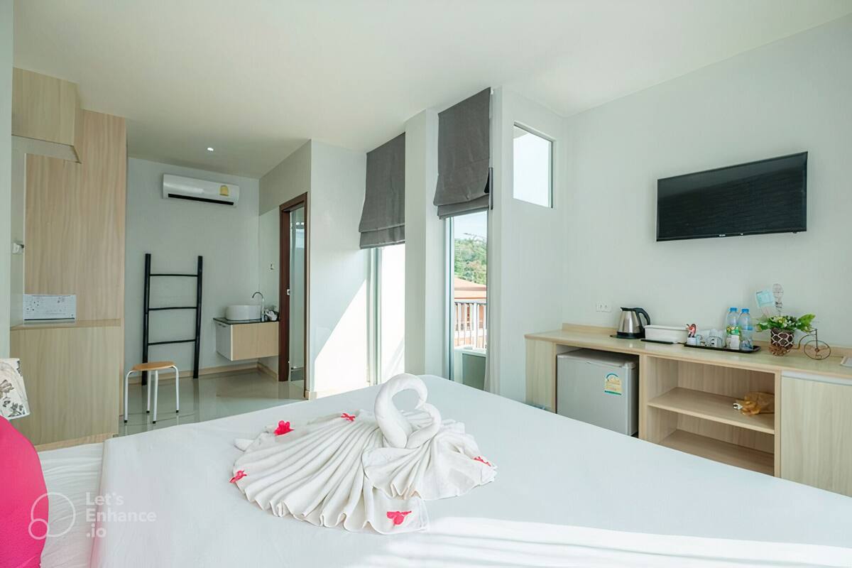 Une chambre d’hôtel équipée d’un lit, d’un bureau, d’une télévision et d’une kitchenette.